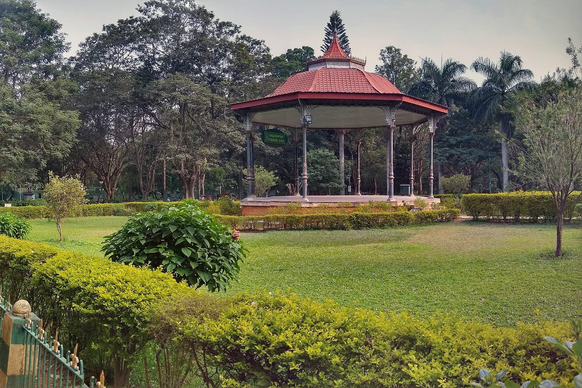 Cubbon Park Timings, Entry Fee and Ticket Prices for the Aquarium, Museum and Toy Train Red-roofed octagonal bandstand on a lawn among trees and hedges in Cubbon Park, Bengaluru