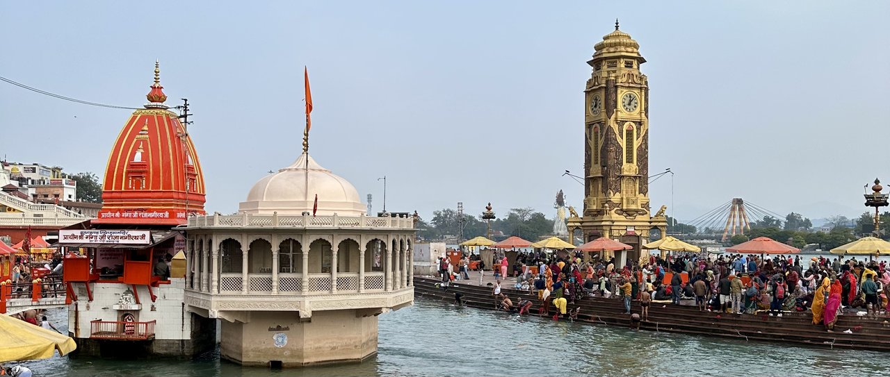 Haridwar to Kainchi Dham Distance: Train + Taxi Route and Travel Time Har Ki Pauri ghat in Haridwar with crowds on the riverfront, temples and the clock tower