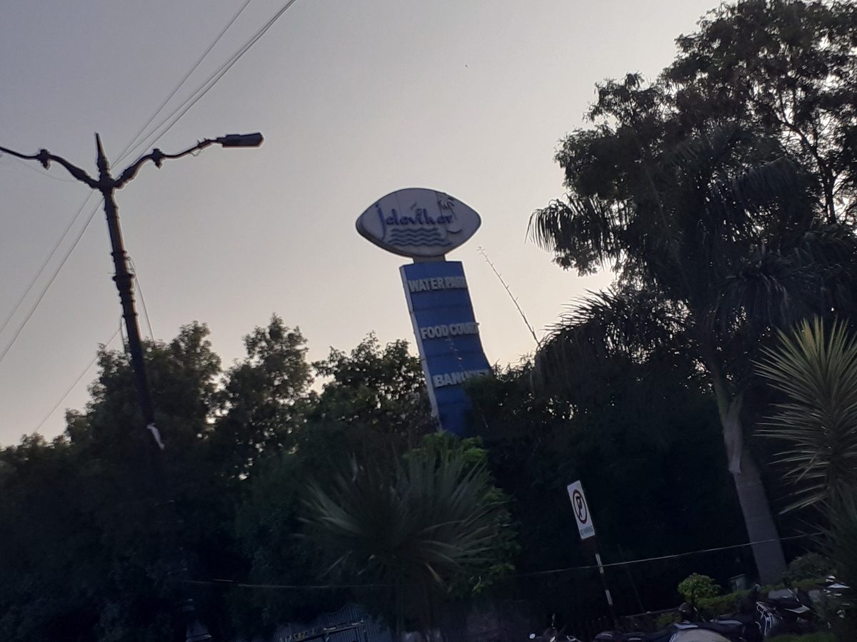Tall Jalavihar sign tower listing water park, food court and banquets above trees on Necklace Road, Hyderabad