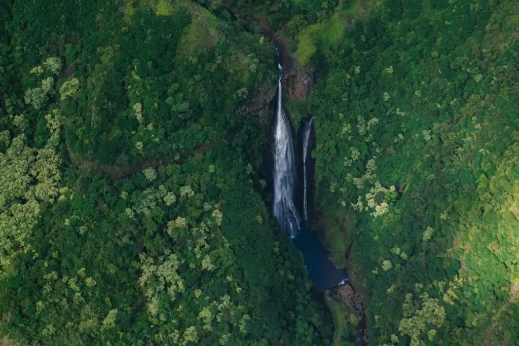 Kauai Trip Planning Tips: Must-See Trails & Beaches kauai trip planning tips with lush green valley and waterfall aerial view