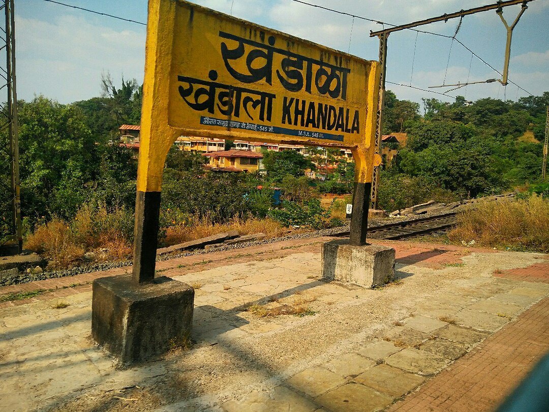 Kune Falls, Lonavala: How to Reach, Entry and Best Time Yellow Khandala railway station name board in Marathi, Hindi and English on a platform, with trees and houses behind it