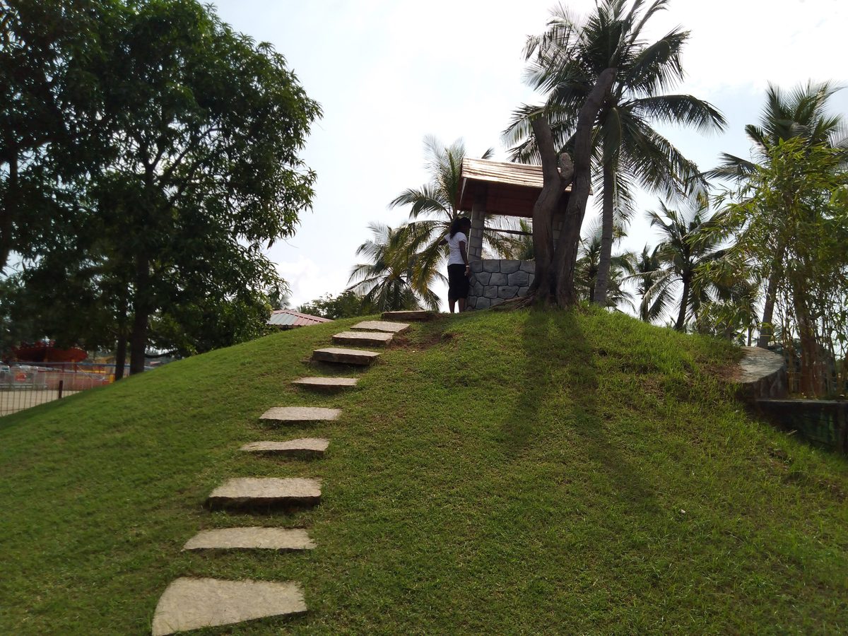 MGM Dizzee World Ticket Price 2026, Timings and Visitor Guide Stone steps up a grassy model hill with a small well on top, themed on Jack and Jill, at MGM Dizzee World, Chennai