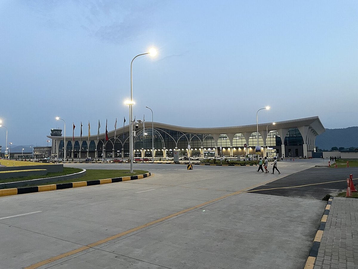 Kathmandu to Pokhara Distance: By Road, Bus Fare and Flight Time The terminal building of Pokhara International Airport at dusk, with a curved roof, flags and street lights in front