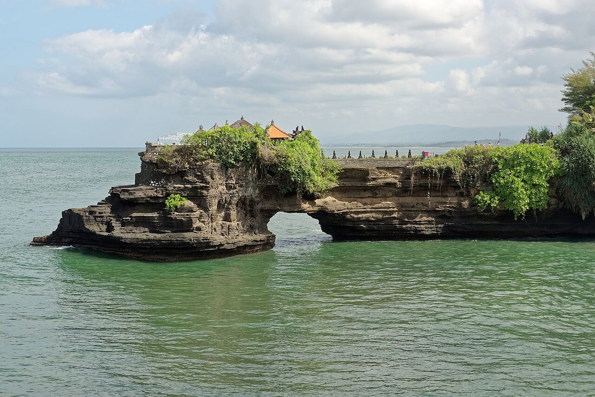 Pura Batu Bolong temple on a natural rock arch over the sea near Tanah Lot, Bali