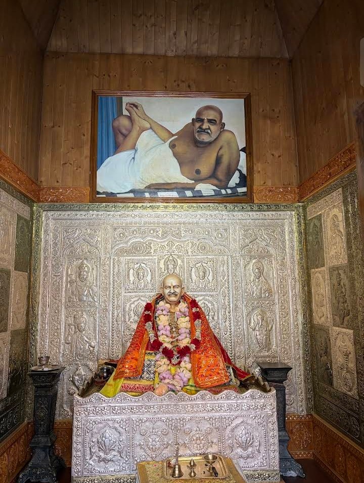 Neem Karoli Baba Ashrams in India: Kainchi, Vrindavan, Lucknow and More Shrine to Neem Karoli Baba in the Sankat Mochan temple complex, Shimla, with a seated murti in an orange robe and a framed photo of the saint above