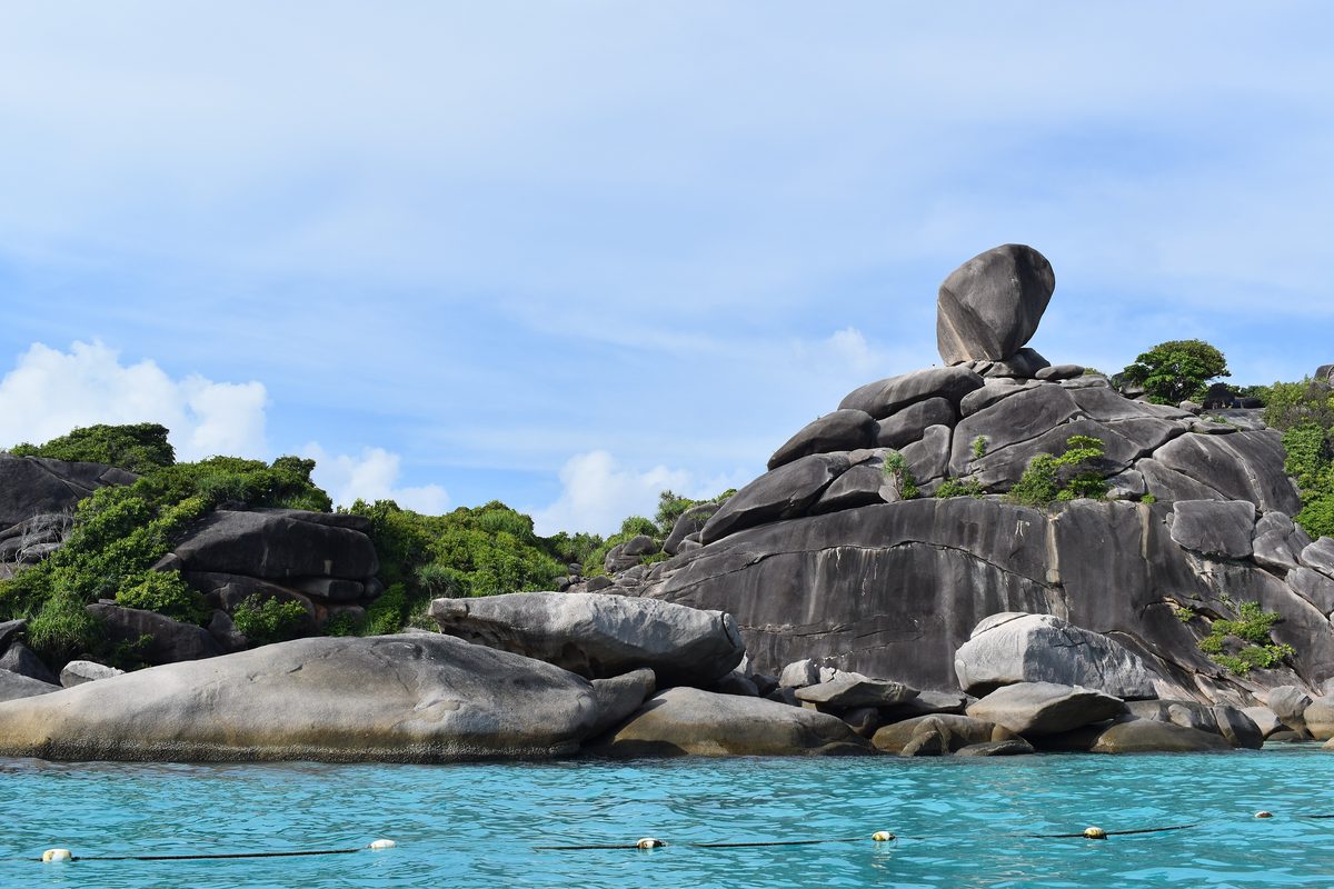 Granite boulders and the balanced Sail Rock above clear water at Donald Duck Bay, Ko Similan