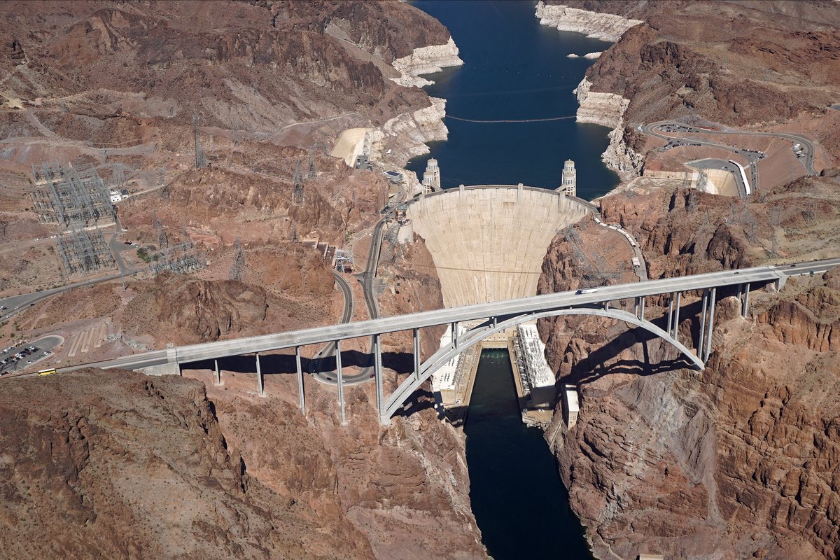 Las Vegas to Grand Canyon South Rim Distance: Route via Kingman and Williams, Drive Time and Bus Options Aerial view of the Mike O'Callaghan–Pat Tillman Memorial Bridge carrying US-93 over the Colorado River, with Hoover Dam and Lake Mead behind it