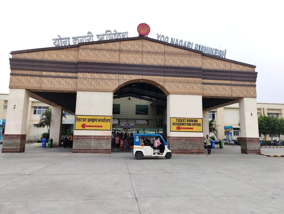 Entrance of Yog Nagari Rishikesh railway station with the station name in Hindi and English and an e-rickshaw in front